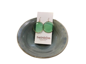 Large green circle in gold earrings